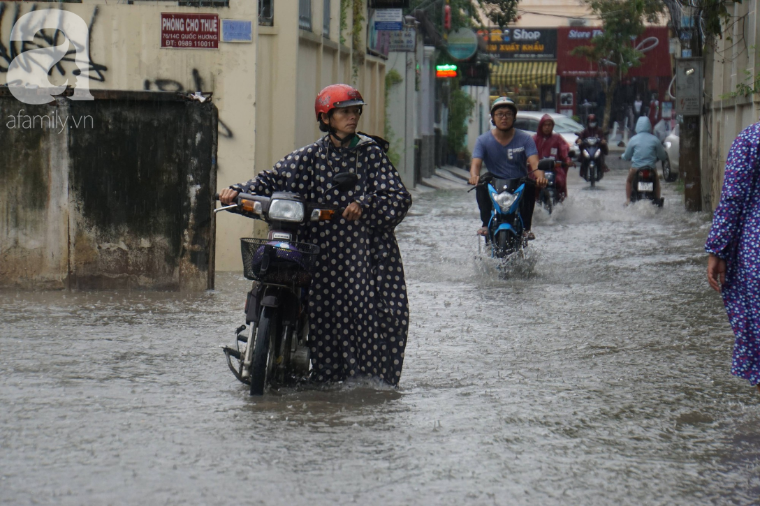 khu biet thu o sai gon ngap nang sau mua tre em truong quoc te duoc bo me cong tren vai loi nuoc ve nha