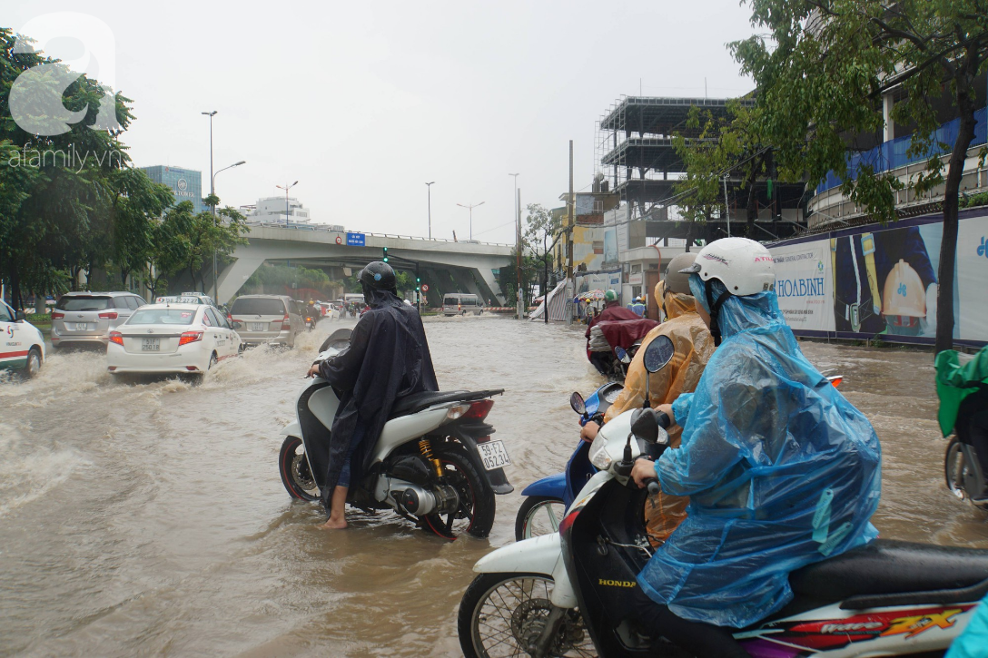 khu biet thu o sai gon ngap nang sau mua tre em truong quoc te duoc bo me cong tren vai loi nuoc ve nha