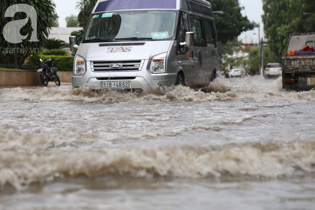 khu biet thu o sai gon ngap nang sau mua tre em truong quoc te duoc bo me cong tren vai loi nuoc ve nha
