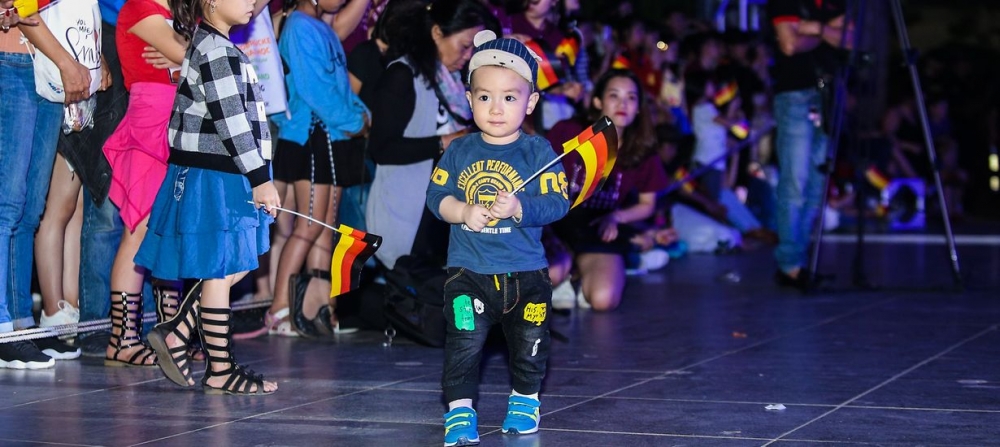 Một em bé Việt Nam đang cầm cờ Đức vui chơi trên đường phố. Ảnh: Một em bé Việt Nam đang cầm cờ Đức vui chơi trên đường phố. Ảnh: