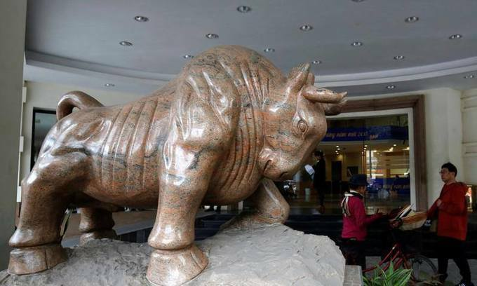 People walk past the stock exchange center in Hanoi. Photo by Reuters 3109 ck3