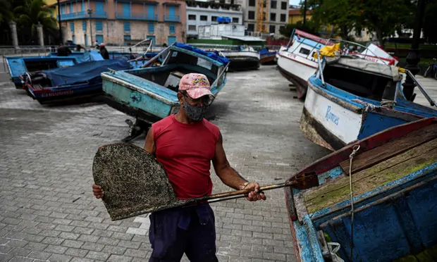 A fisherman secures his boat to land ahead of the passage of Tropical Storm Elsa in Havana. Photograph: Yamil Lage/AFP/Getty Images A fisherman secures his boat to land ahead of the passage of Tropical Storm Elsa in Havana. Photograph: Yamil Lage/AFP/Getty Images