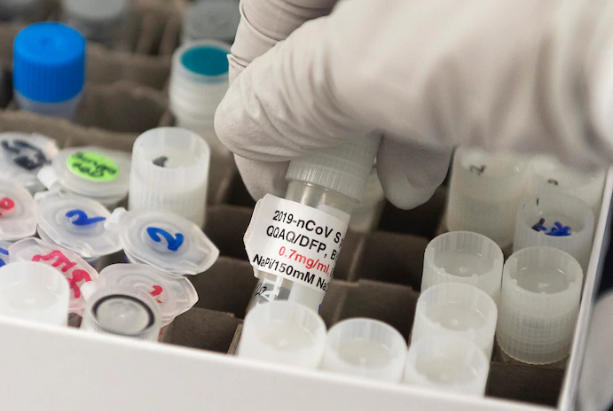 Nita Patel, director of antibody discovery and vaccine development at Maryland-based Novavax labs, lifts a vial containing a potential coronavirus vaccine on March 20. (Andrew Caballero-Reynolds/AFP/Getty Images) 3620 va1