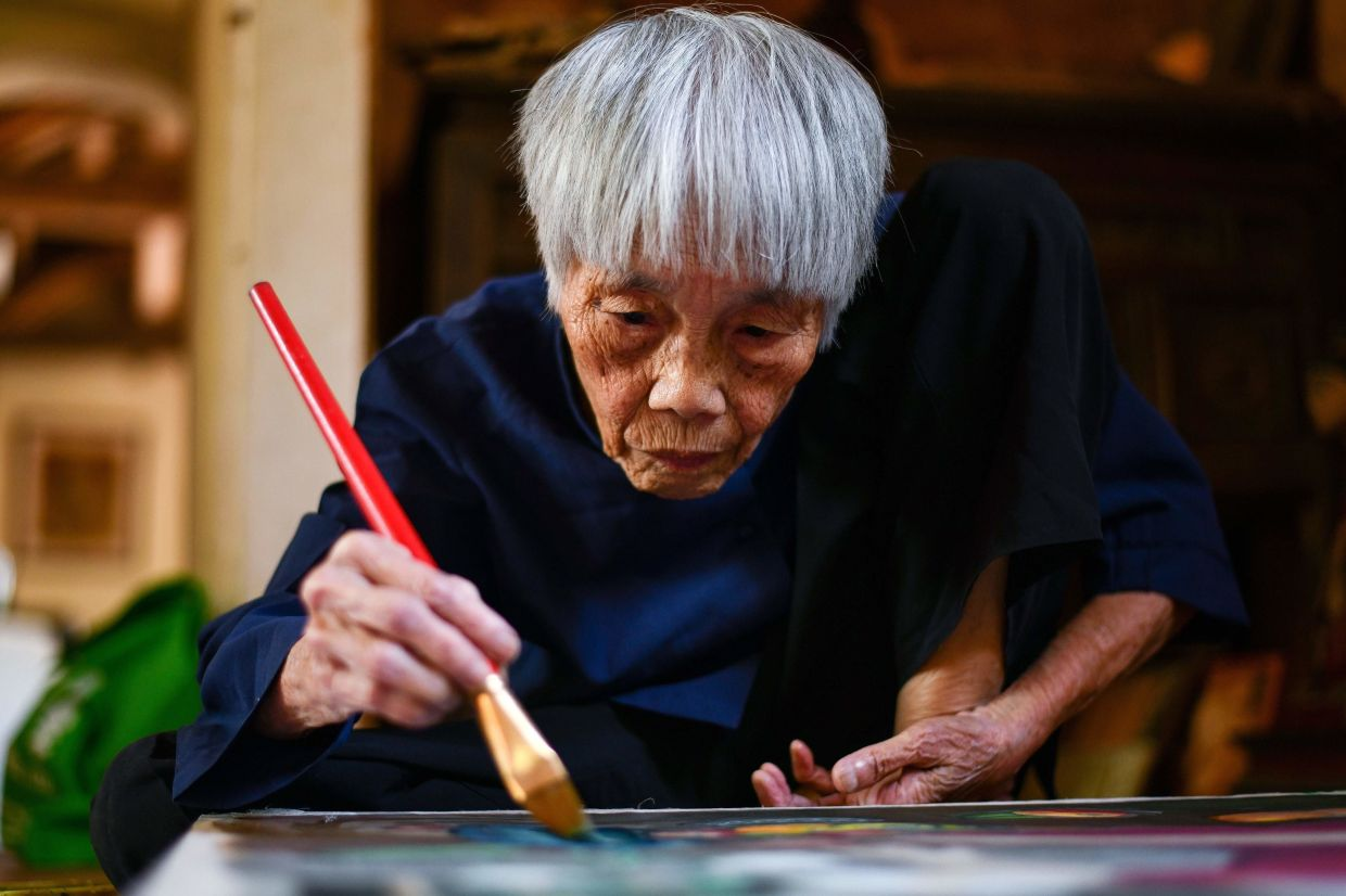 Mong Bich specialises in silk paintings of daily life and ordinary people, women in particular, and ploughed a lonely furrow during many years of war when artists were steered towards the army or frontline workers as subjects. Photo: AFP 5910 mb