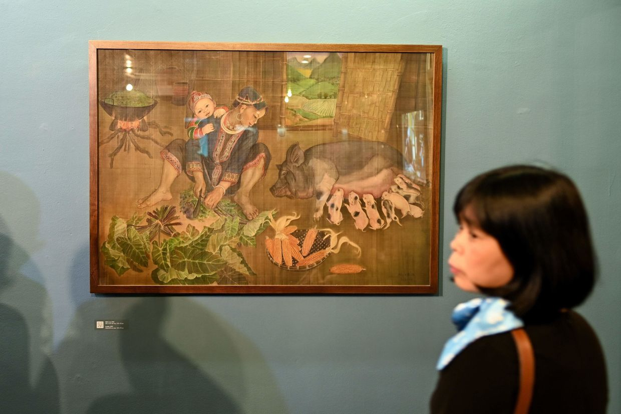 A visitor looking at a painting by Mong Bich during the opening of her first solo exhibition at the French Cultural Centre in Hanoi. Photo: AFP 0018 mb1