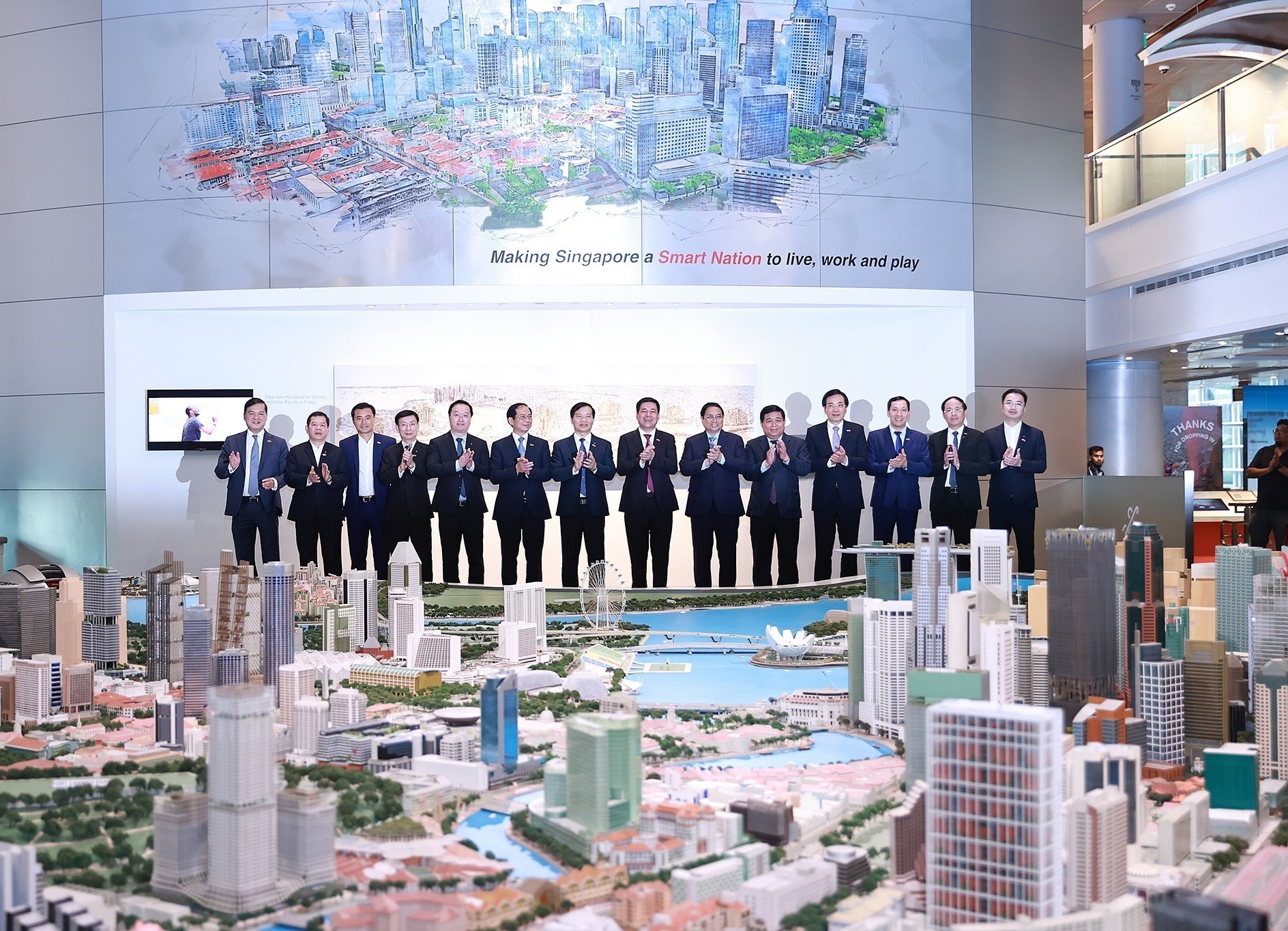 范明政与与会代表参观“智慧国城景”（Smart Nation CityScape）展览会。图自越通社
