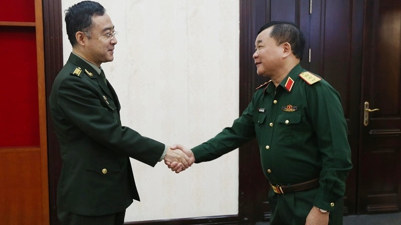 越南国防部副部长黄春战上将(右)会见中国驻越大使馆国防武官潘涛大校。