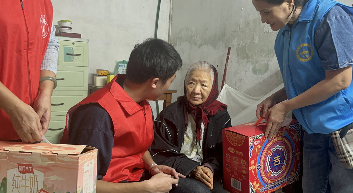 志愿者俯身倾听，与老奶奶亲切交谈