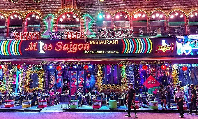 Staff of a bar on Bui Vien Street in HCMC wait for customers on the first reopening day after months of closure due to Covid, January 10, 2022. Photo: VnExpress