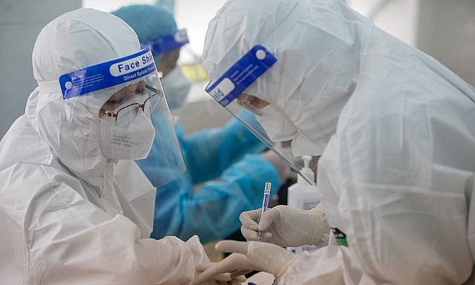 Health workers conduct Covid-19 vaccination at a high school in HCMC's District 1, October 27, 2021. Photo: VnExpress Health workers conduct Covid-19 vaccination at a high school in HCMC's District 1, October 27, 2021. Photo: VnExpress