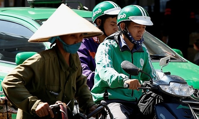 A GrabBike driver at work in Hanoi. Photo: Reuters A GrabBike driver at work in Hanoi. Photo: Reuters