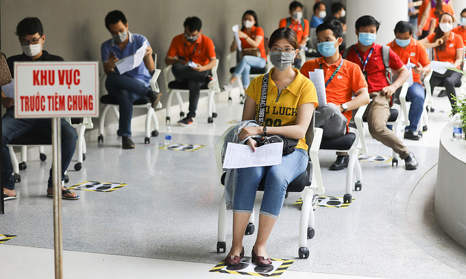 People wait in line for their turn to get the Covid-19 vaccine in HCMC, June 19, 2021. Photo: VnExpress People wait in line for their turn to get the Covid-19 vaccine in HCMC, June 19, 2021. Photo: VnExpress