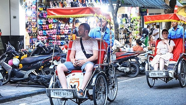 Foreign tourists enjoy a cyclo tour of Hanoi. Photo: VNA Foreign tourists enjoy a cyclo tour of Hanoi. Photo: VNA