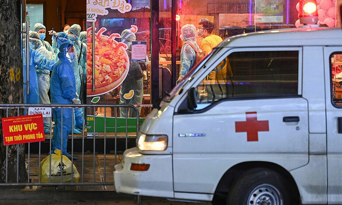 An ambulance and medical workers arrive at a pizza shop on Hanoi's Doan Tran Nghiep Street to lock it down due to Covid linkage, July 15, 2021. Photo: VnExpress An ambulance and medical workers arrive at a pizza shop on Hanoi's Doan Tran Nghiep Street to lock it down due to Covid linkage, July 15, 2021. Photo: VnExpress