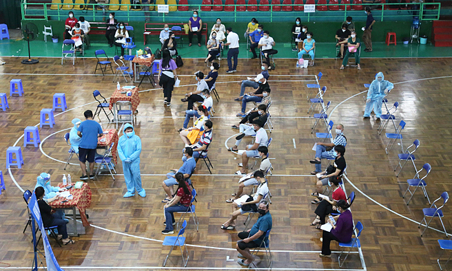 People wait for receiving Covid vaccine at a sports center in HCMC's District 11, July 22, 2021. Photo: VnExpress People wait for receiving Covid vaccine at a sports center in HCMC's District 11, July 22, 2021. Photo: VnExpress