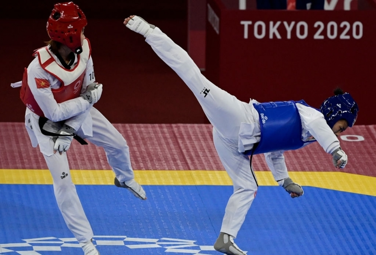Kim Tuyen (in red gi) defeats Yvette Yong of Canada to enter the quarter-finals. Photo: Getty Kim Tuyen (in red gi) defeats Yvette Yong of Canada to enter the quarter-finals. Photo: Getty
