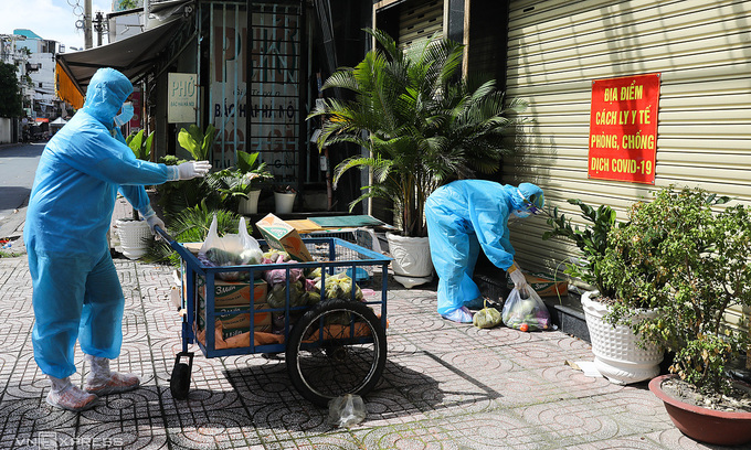 Volunteers distribute food to families under lockdown in HCMC's District 3, July 2021. Photo: VnExpress