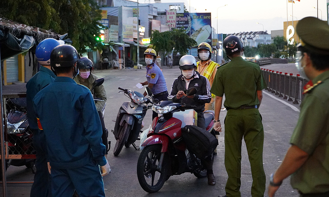 Police officers at a Covid-19 checkpoint stop vehicles in HCMC's Go Vap District, July 26, 2021. Photo: VnExpress Police officers at a Covid-19 checkpoint stop vehicles in HCMC's Go Vap District, July 26, 2021. Photo: VnExpress