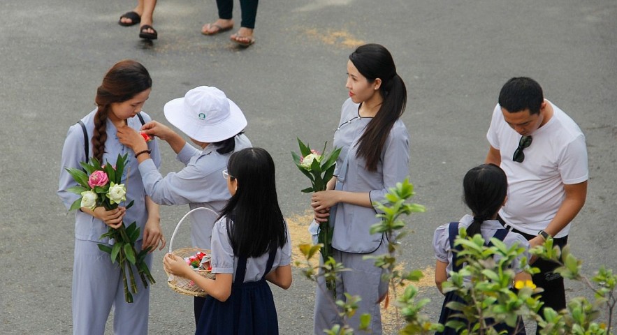 Worshipers at Phổ Quang Temple in Saigon are given either a red of white rose before joining festivities. The red one is for those who have a mother, and the white one is for those without. Photo: saigoneer Worshipers at Phổ Quang Temple in Saigon are given either a red of white rose before joining festivities. The red one is for those who have a mother, and the white one is for those without. Photo: saigoneer