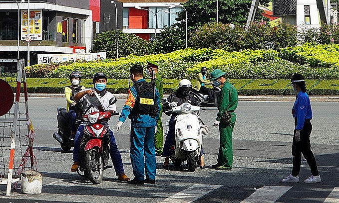 Forces check travel papers of people at a Covid checkpoint on Nguyen Binh Khiem Street in HCMC, August 23 2021. Photo: VnExpress Forces check travel papers of people at a Covid checkpoint on Nguyen Binh Khiem Street in HCMC, August 23 2021. Photo: VnExpress