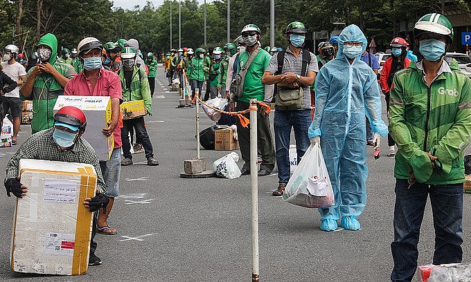Shippers wait to deliver packages at a field hospital in Thu Duc, HCMC, July 21, 2021. Photo: VnExpress Shippers wait to deliver packages at a field hospital in Thu Duc, HCMC, July 21, 2021. Photo: VnExpress