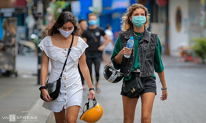 Foreign tourists walk on Bui Vien backpacker street in downtown HCMC, March 2020. Photo: VnExpress Foreign tourists walk on Bui Vien backpacker street in downtown HCMC, March 2020. Photo: VnExpress