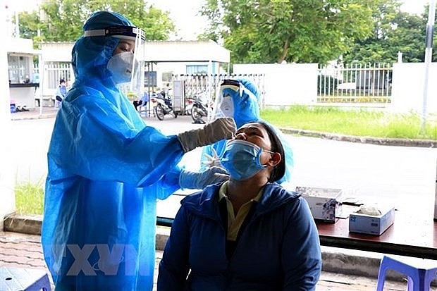 A health worker takes samples for Covid-19 testing. Photo: VNA A health worker takes samples for Covid-19 testing. Photo: VNA