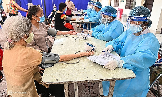 Two elderly women have their blood pressure checked before vaccination at a Covid-19 testing site in Hanoi's Ba Dinh District, September 10, 2021. Photo: VnExpress Two elderly women have their blood pressure checked before vaccination at a Covid-19 testing site in Hanoi's Ba Dinh District, September 10, 2021. Photo: VnExpress