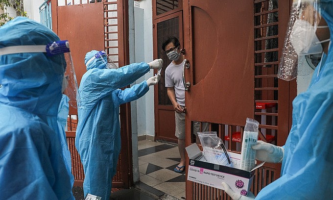Medical staff instruct a man on Covid-19 testing in HCMC's Binh Thanh District, August 23, 2021. Photo: VnExpress Medical staff instruct a man on Covid-19 testing in HCMC's Binh Thanh District, August 23, 2021. Photo: VnExpress