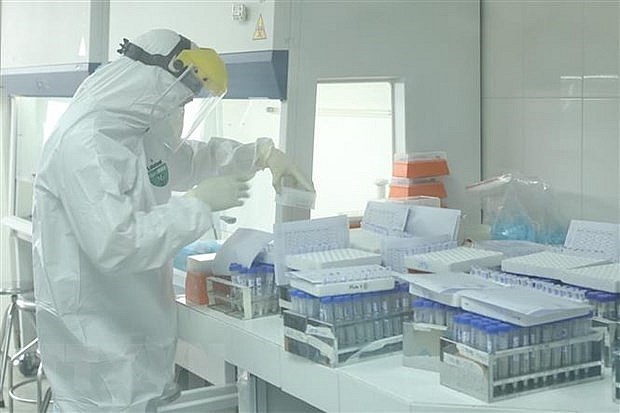 A health worker handles samples for COVID-19 testing at the Hanoi Centre for Disease Control. Photo: VNA A health worker handles samples for COVID-19 testing at the Hanoi Centre for Disease Control. Photo: VNA