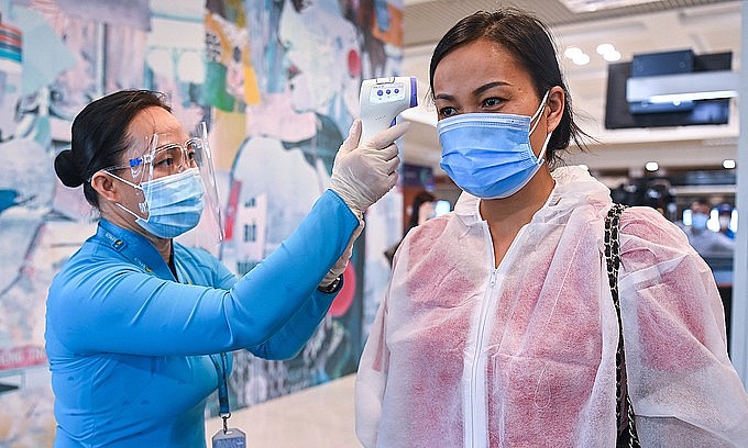 A passenger (R) has her body temperature checked at Noi Bai International Airport in Hanoi, October 2021. Photo: VnExpress A passenger (R) has her body temperature checked at Noi Bai International Airport in Hanoi, October 2021. Photo: VnExpress