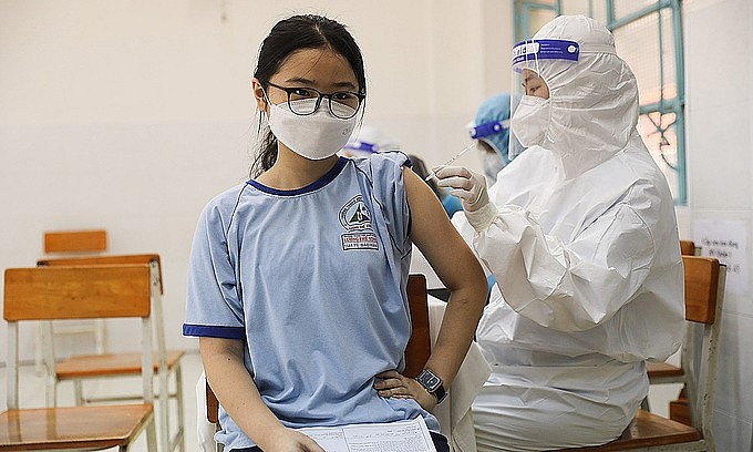 A girl receives a Covid-19 vaccine shot in HCMC's District 1, October 27, 2021. Photo: VnExpress A girl receives a Covid-19 vaccine shot in HCMC's District 1, October 27, 2021. Photo: VnExpress