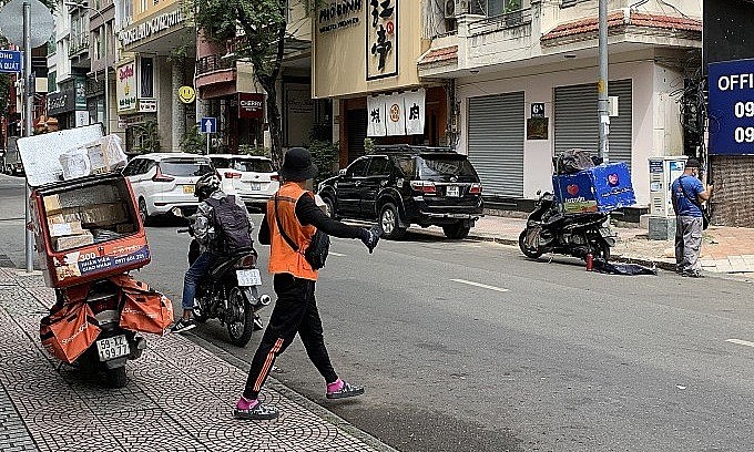 Delivery workers for e-commerce platforms Shopee (orange) and Lazada (blue) wait for customers on Cao Ba Quat Road in HCMC’s District 1, Nov. 16, 2021. Photo: VnExpress Delivery workers for e-commerce platforms Shopee (orange) and Lazada (blue) wait for customers on Cao Ba Quat Road in HCMC’s District 1, Nov. 16, 2021. Photo: VnExpress