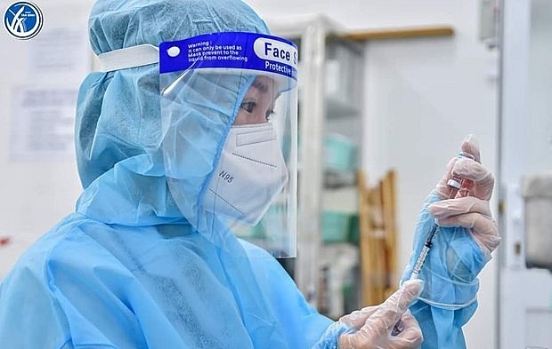 A medic is about to inject a Covid-19 vaccine shot. Photo: VNA A medic is about to inject a Covid-19 vaccine shot. Photo: VNA