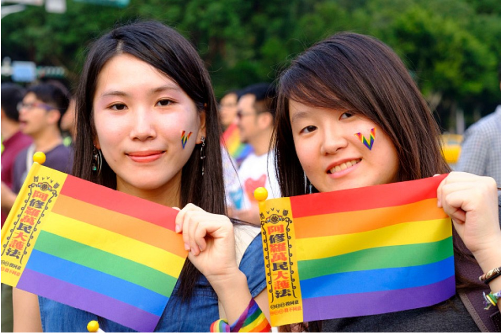 Two young women at an LGBT organized rally in Taipei hold rainbow flags in support of same sex marriage)[LightRocket/Getty/Kyodo 2213 capture