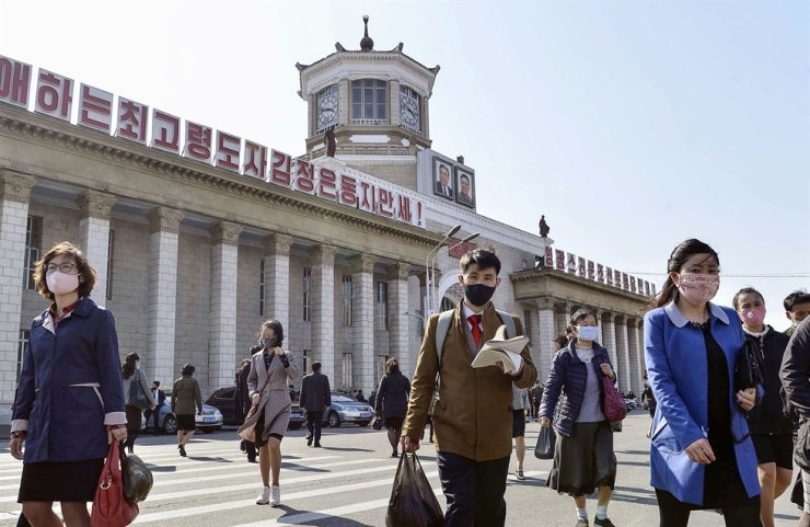 People wearing protective face masks walk amid concerns over the new coronavirus disease (COVID-19) in front of Pyongyang Station in Pyongyang, North Korea, April 27, 2020. Kyodo via Reuters 0902 optimize 1