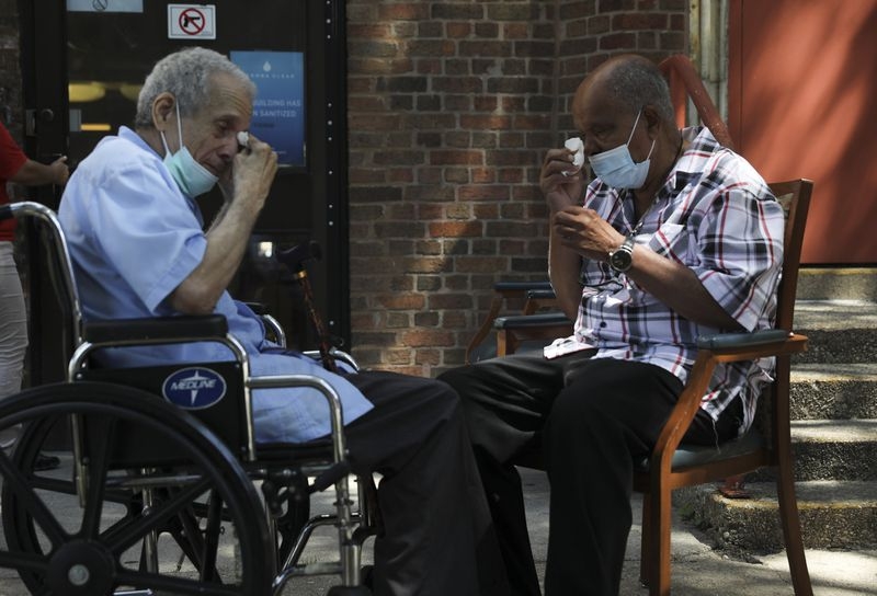 Antonio Talavera, 77, left, and his older brother, Manuel Talavera, 82, wipe tears from their eyes during a second meeting outside the Center Home nursing home in Humboldt Park July 14, 2020. They had seen each other for the first time in 40 years just three weeks prior. (Abel Uribe / Chicago Tribune) 5033 mgtojgfb65a27blbf3hquv7lpy