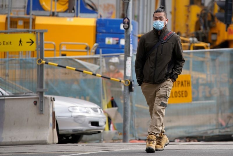 A man wearing a protective face mask walks in a street in Melbourne after it became the first city in Australia to enforce mask-wearing in public as part of efforts to curb a resurgence of the coronavirus disease (COVID-19), July 23, 2020. REUTERS/Sandra Sanders 0318 805978