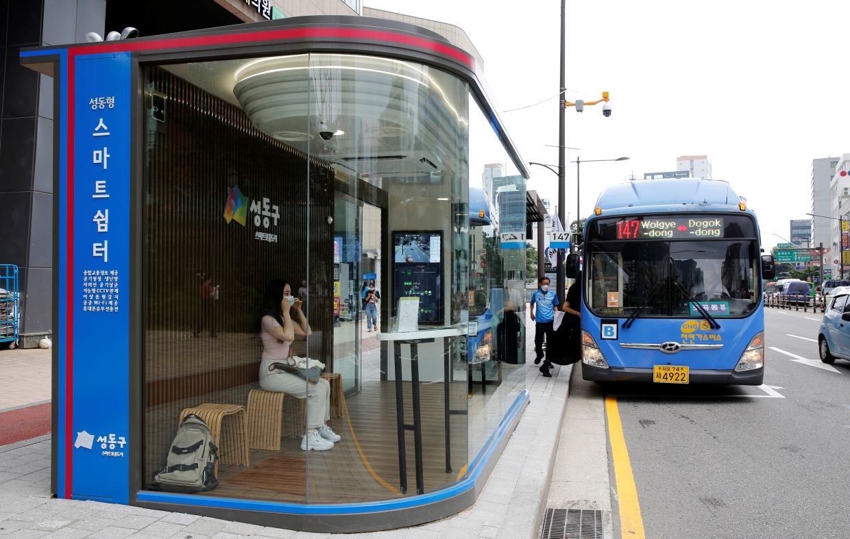 A woman wears a mask inside a glass-covered bus stop in which a thermal imaging camera, UV steriliser, air conditioner, CCTV and digital signage are set, to avoid the spread of Covid-19 in Seoul, South Korea. Photo: Reuters 3004 821342