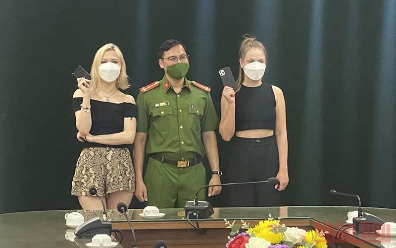 Hai du khách người Nga vui vẻ nhận lại điện thoại từ Công an quận Hoàn Kiếm