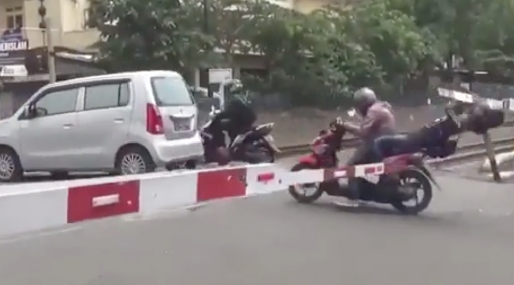 Video: Thanh niên cố vượt thanh chắn đường tàu khiến bạn gái ngồi sau gặp quả đắng